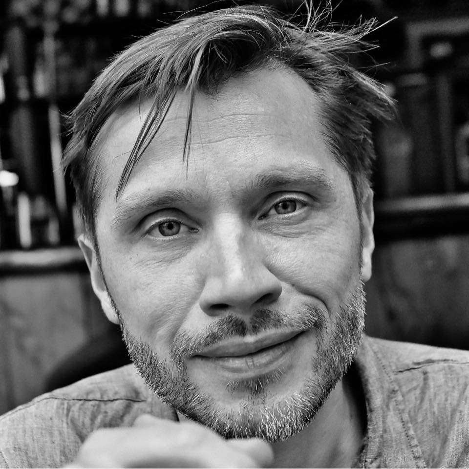 Black-and-white portrait of Caspar Schjelbred, looking directly at the camera with a calm, attentive expression.